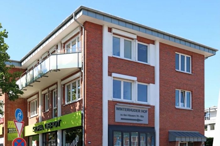 Klinkerhaus Winterhuder Weg 86 mit Balkonen und dem Schild Winterhuder Hof